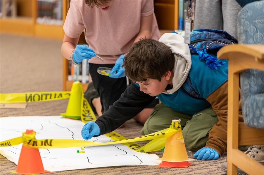   Pulaski Middle School Science Club students examine a crime scene during a recent project.